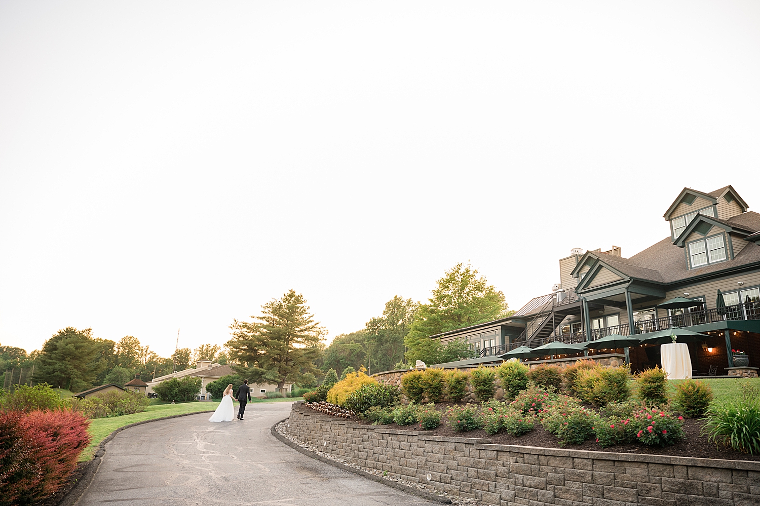 couple portrait on walkway with golf club in the background