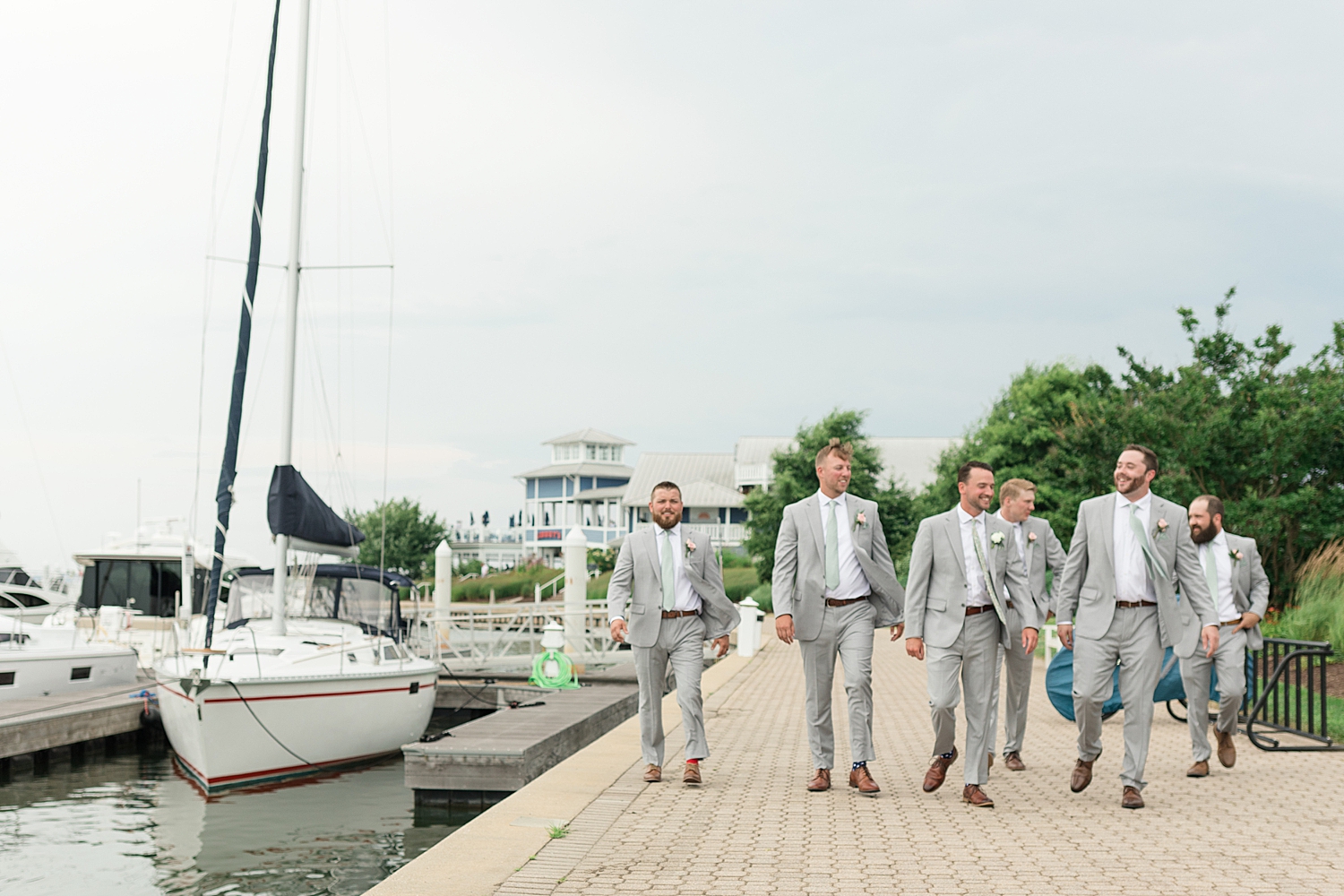 groom and groomsmen walking along pier