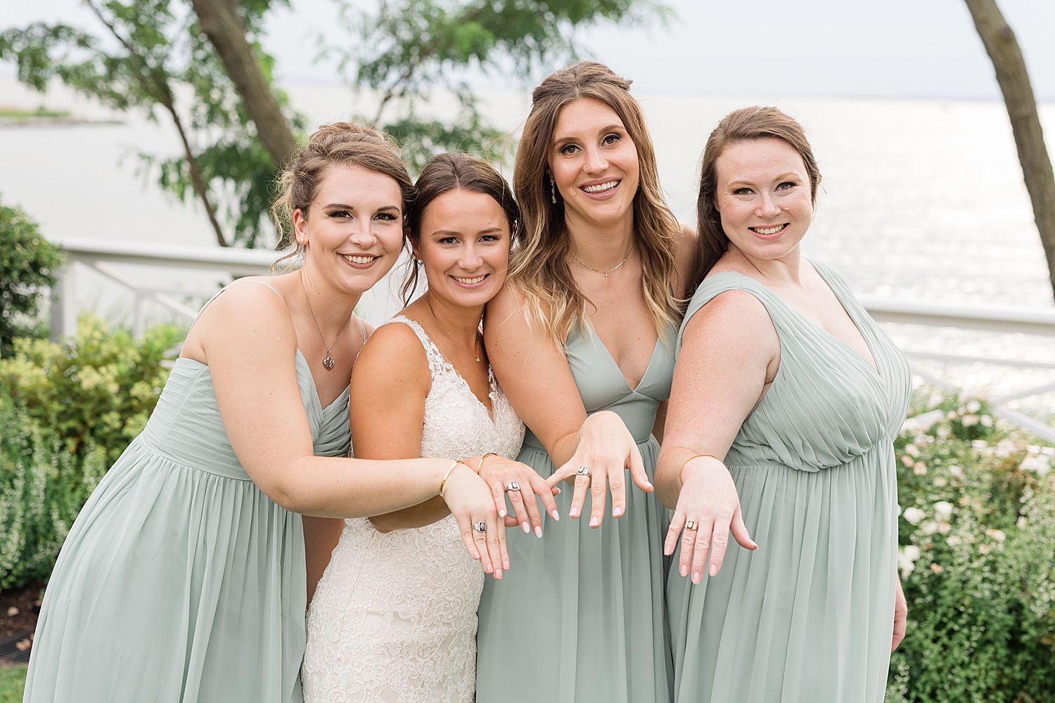 bride and bridesmaids showing off wedding rings