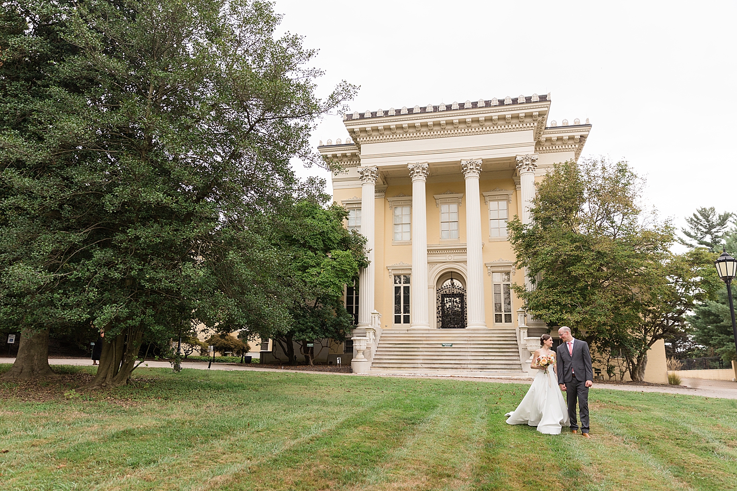 bride and groom in front of evergreen museum