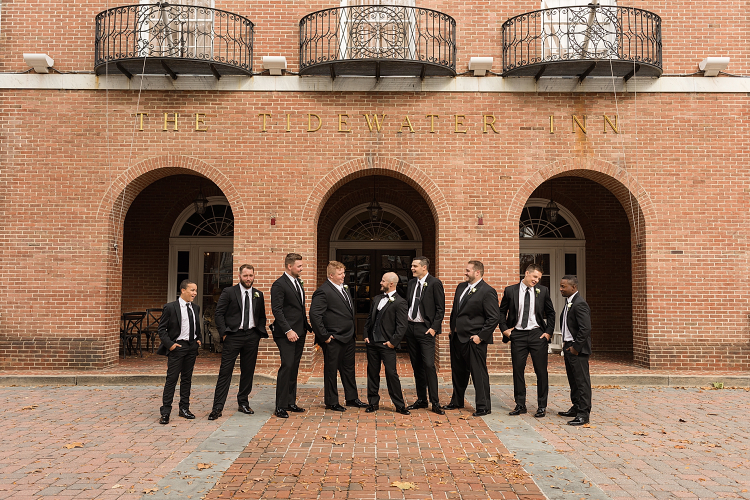 groomsmen in front of brick arches at tidewater inn