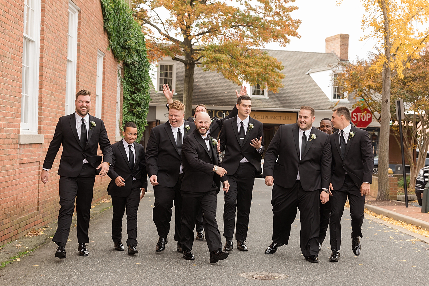 groom and groomsmen walk down the street