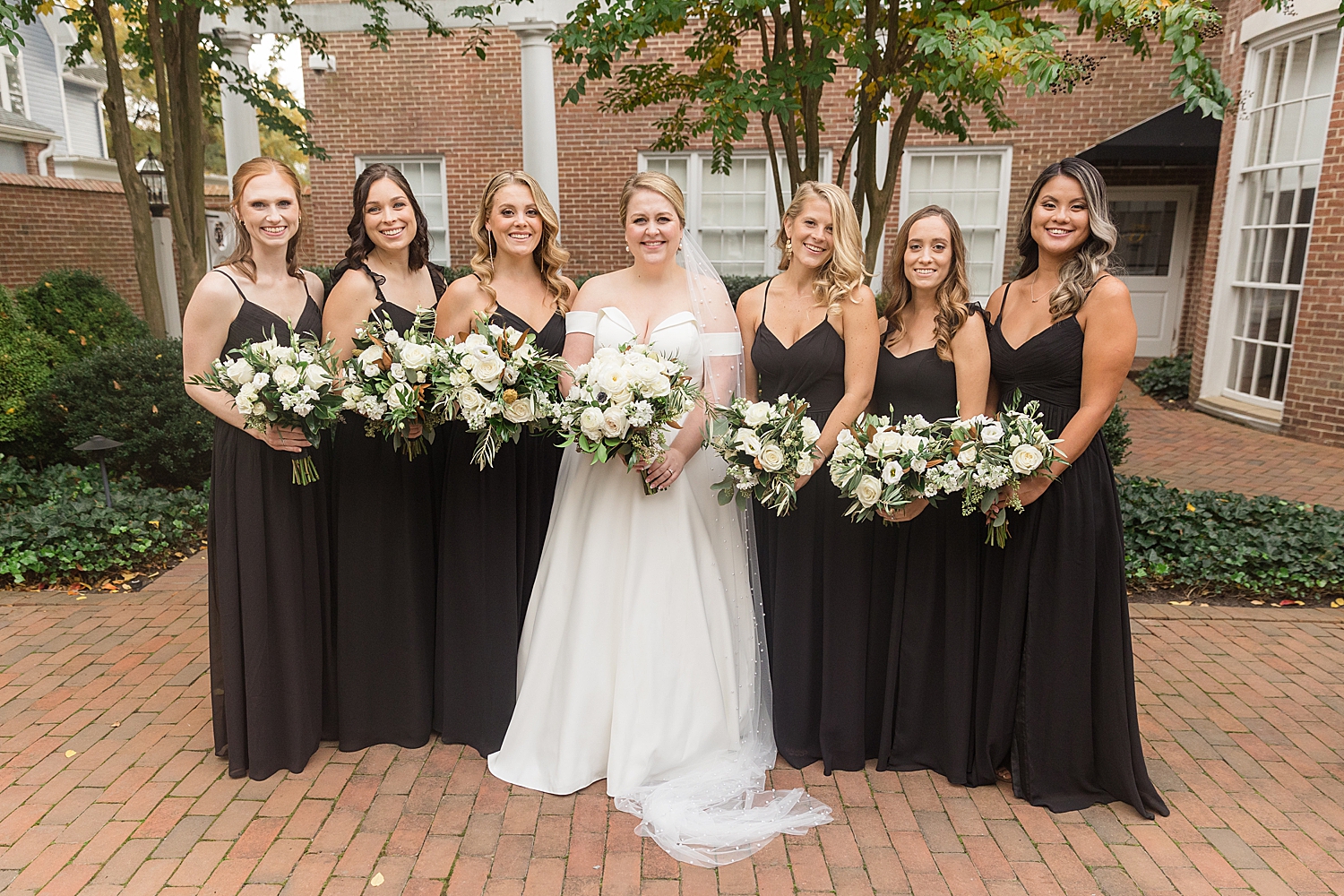 bride and bridesmaids in black with white bouquets