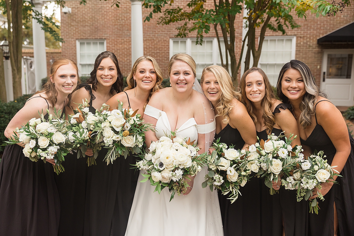 bride and bridesmaids in black with white bouquets