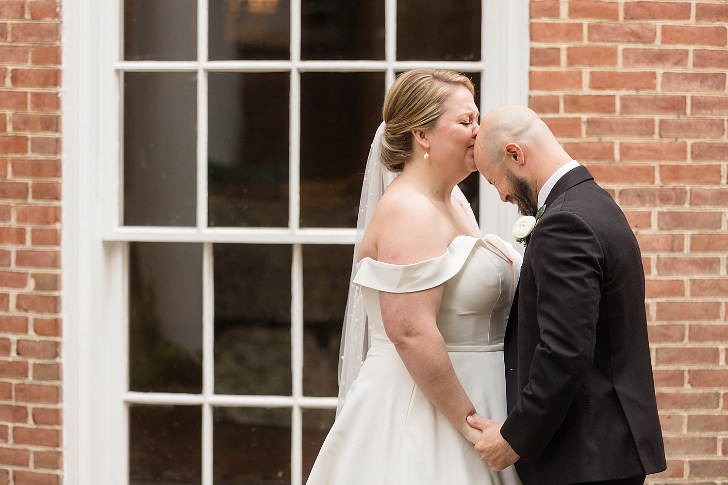 bride kisses groom's bald head