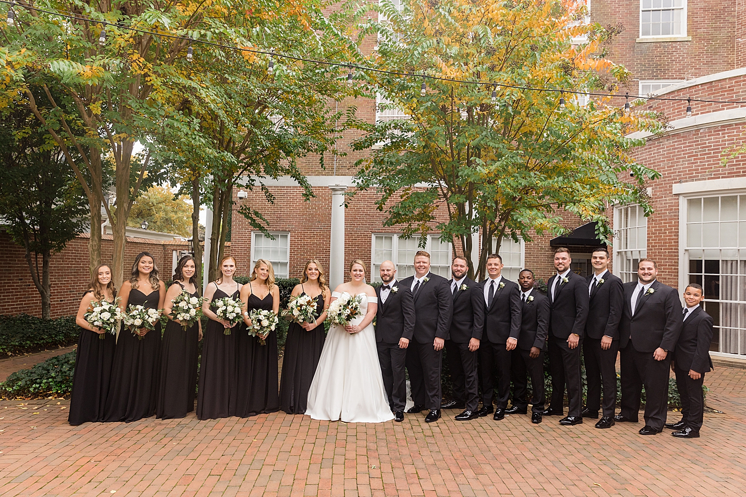 full bridal party in front of brick building