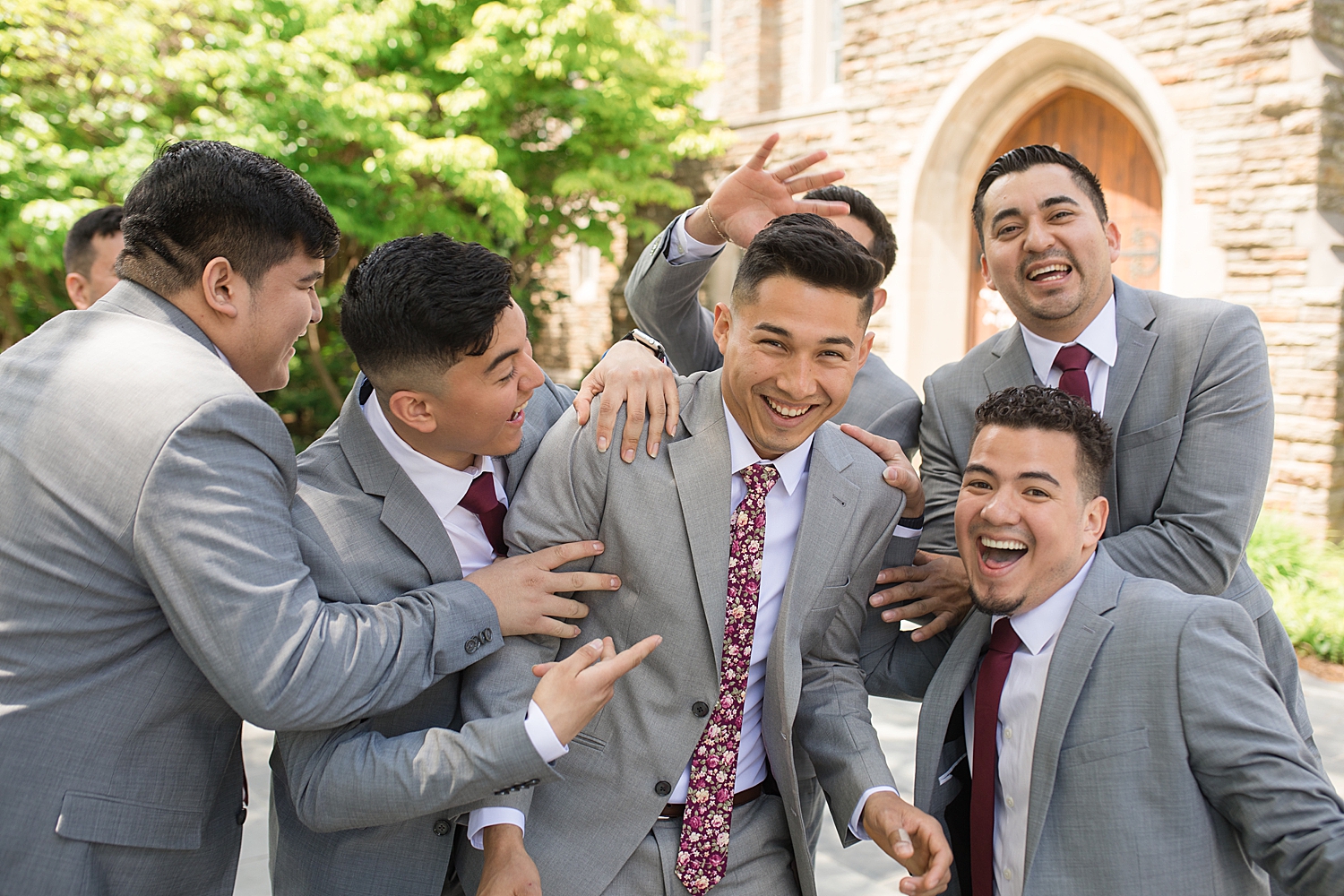 groomsmen mess with groom in front of chapel