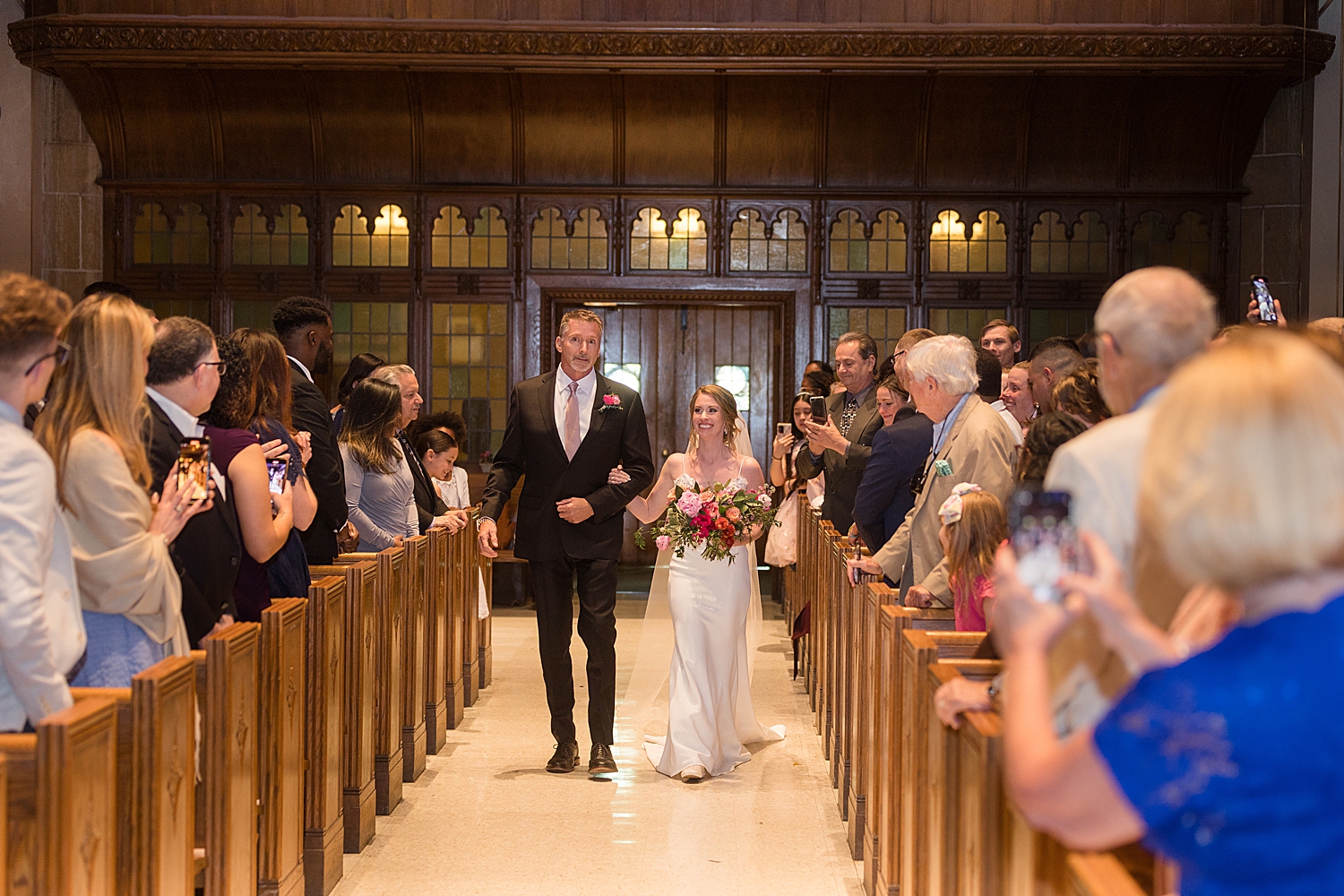 bride's dad walks her down the aisle at loyola chapel