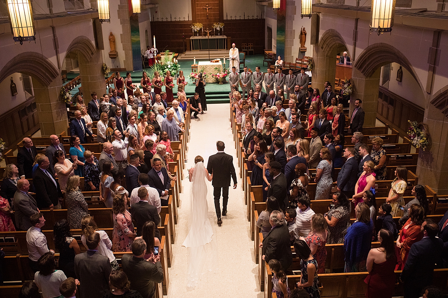 bride's dad walks her down the aisle at loyola chapel