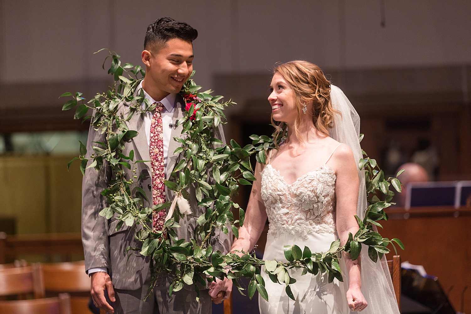 bride and groom draped in greenery