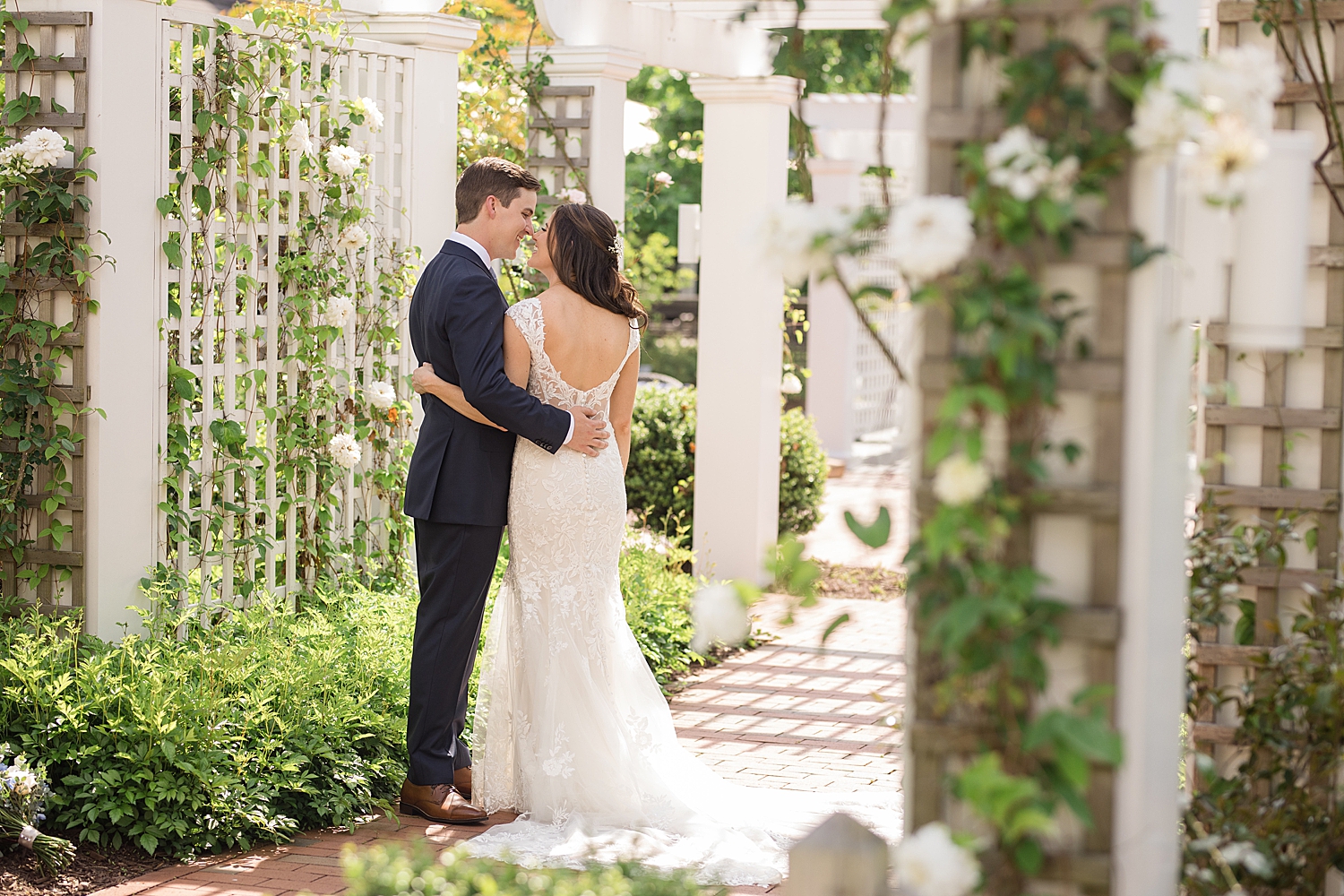 couple embrace under trellis