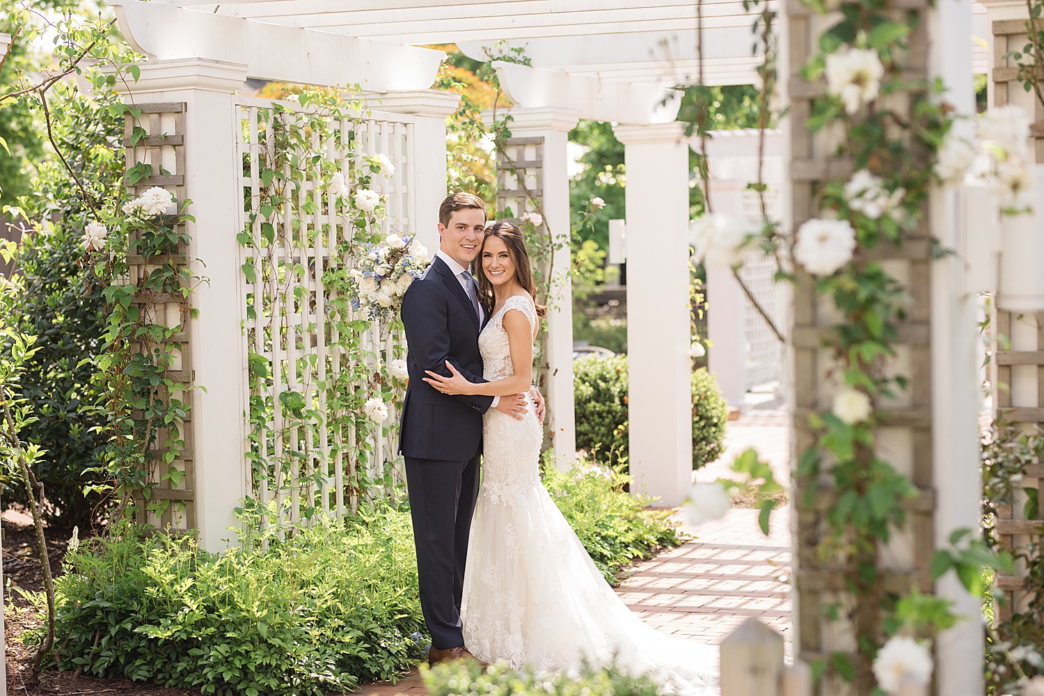 couple embrace under trellis