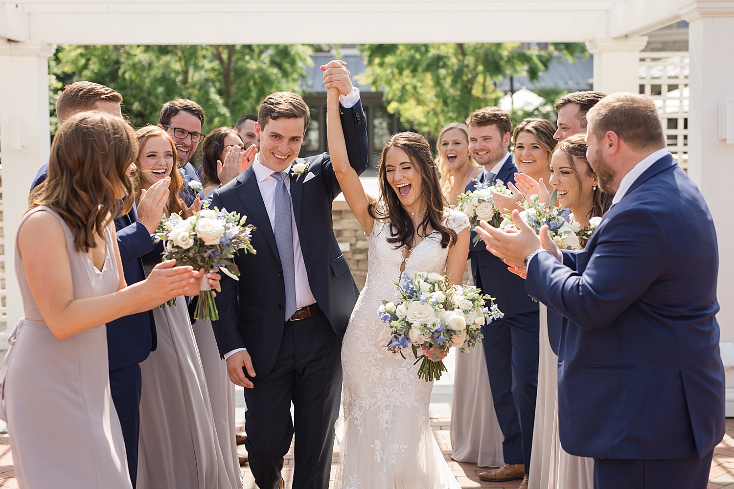 couple kiss while wedding party cheers