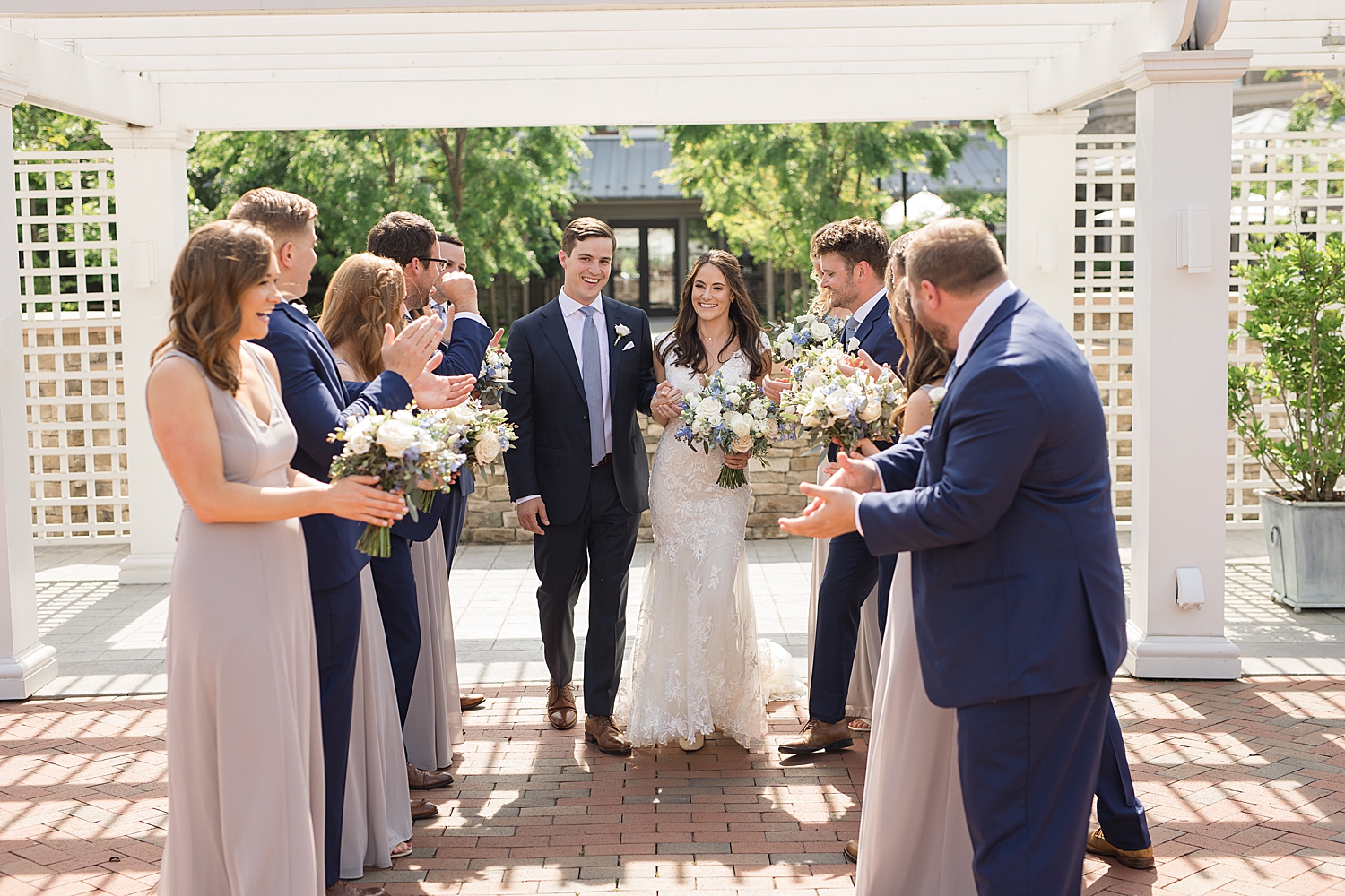 couple kiss while wedding party cheers