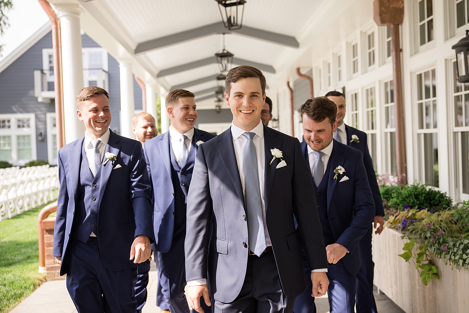 groom and groomsmen walk down path