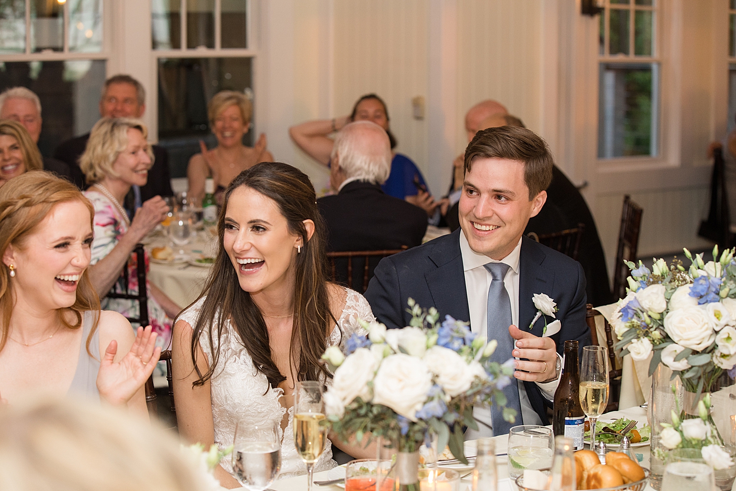 bride and groom laugh at head table