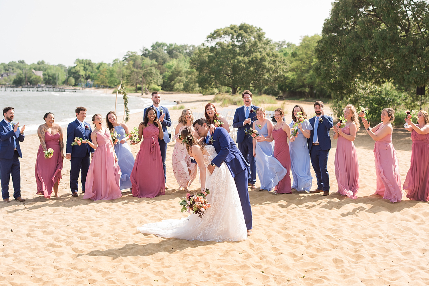 wedding party cheering while couple kiss