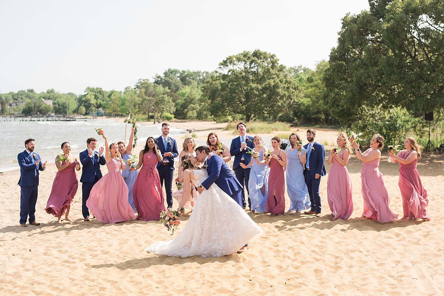 wedding party cheering while couple kiss