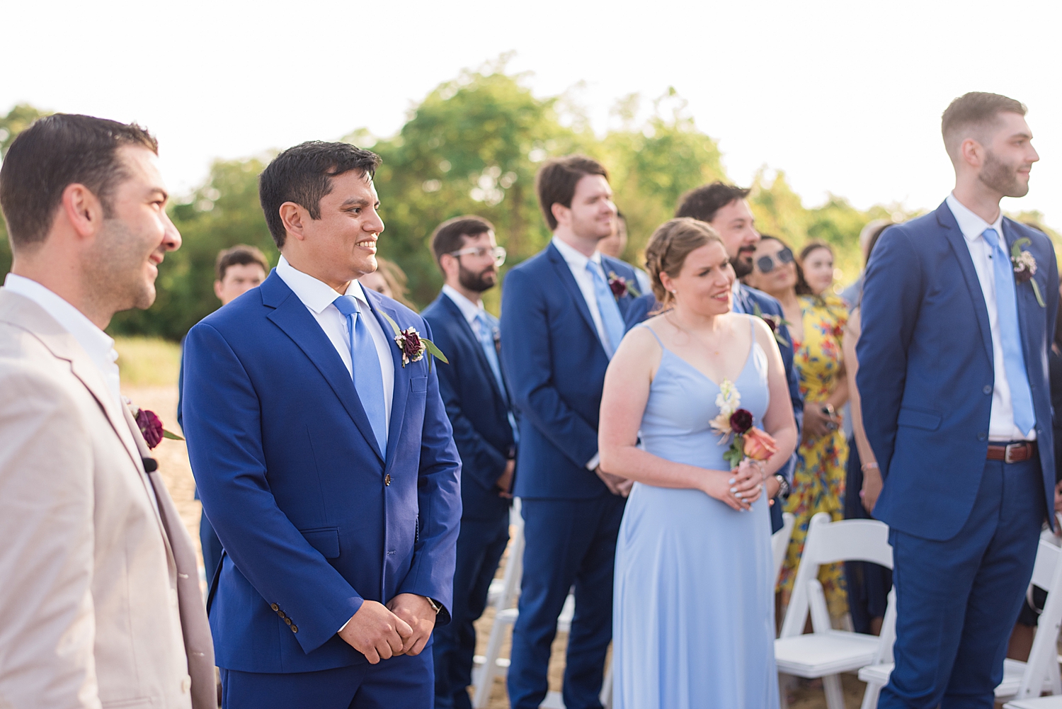 groom waits for bride at the end of the aisle