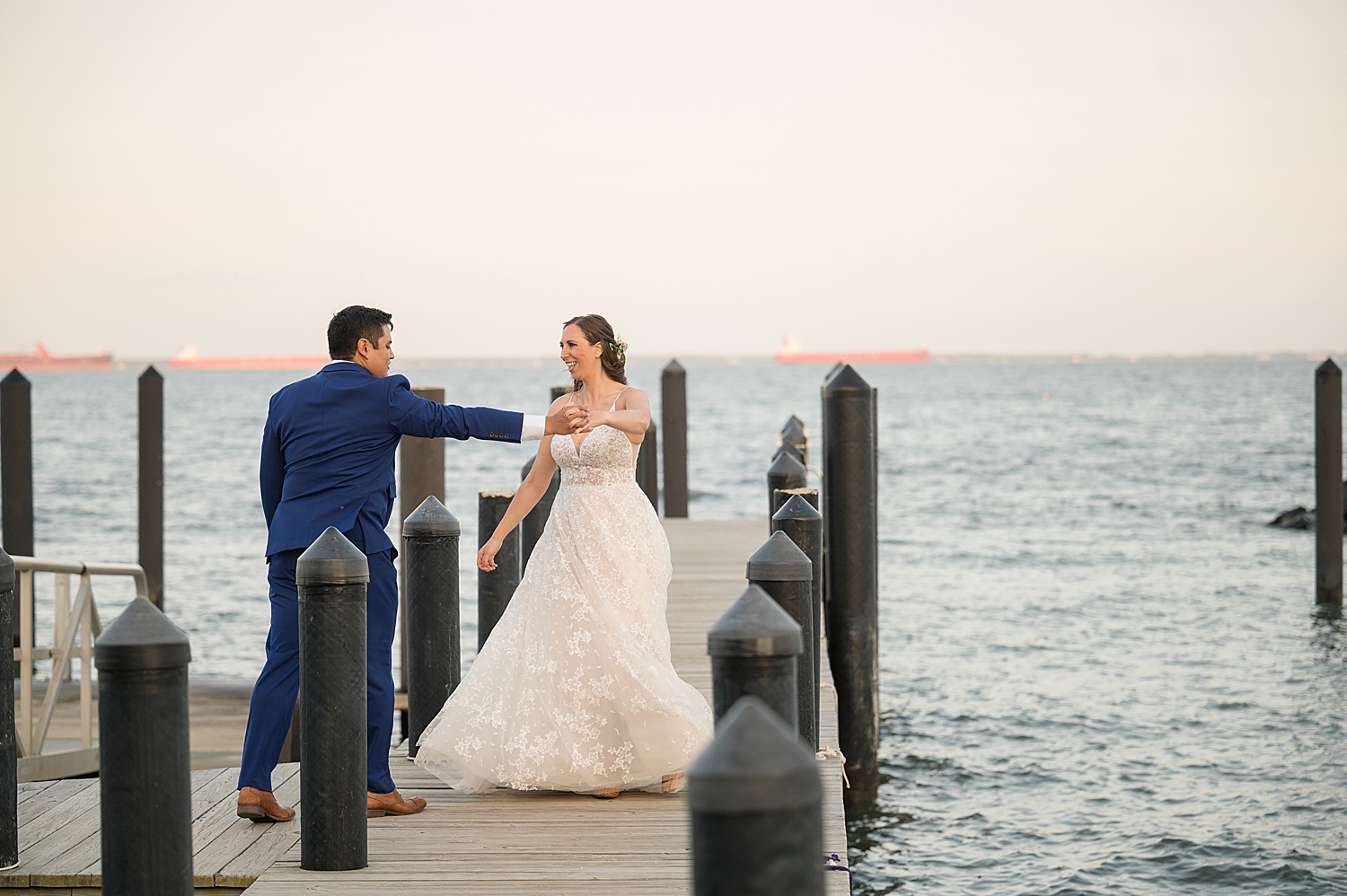 bride and groom spin on pier