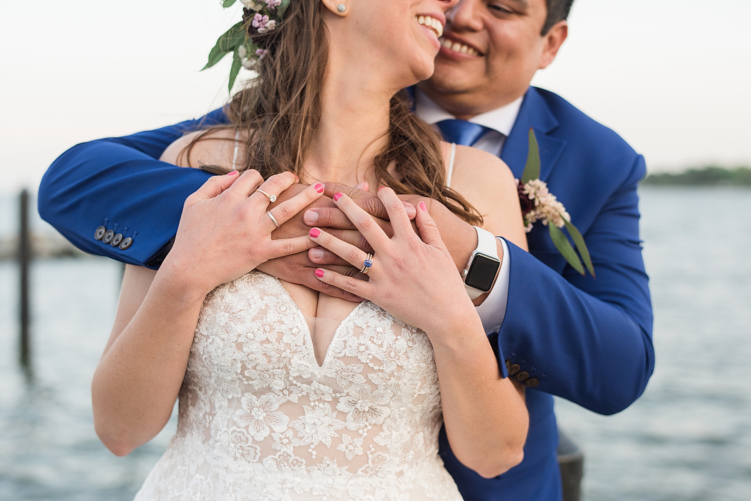 bride and groom embrace on pier