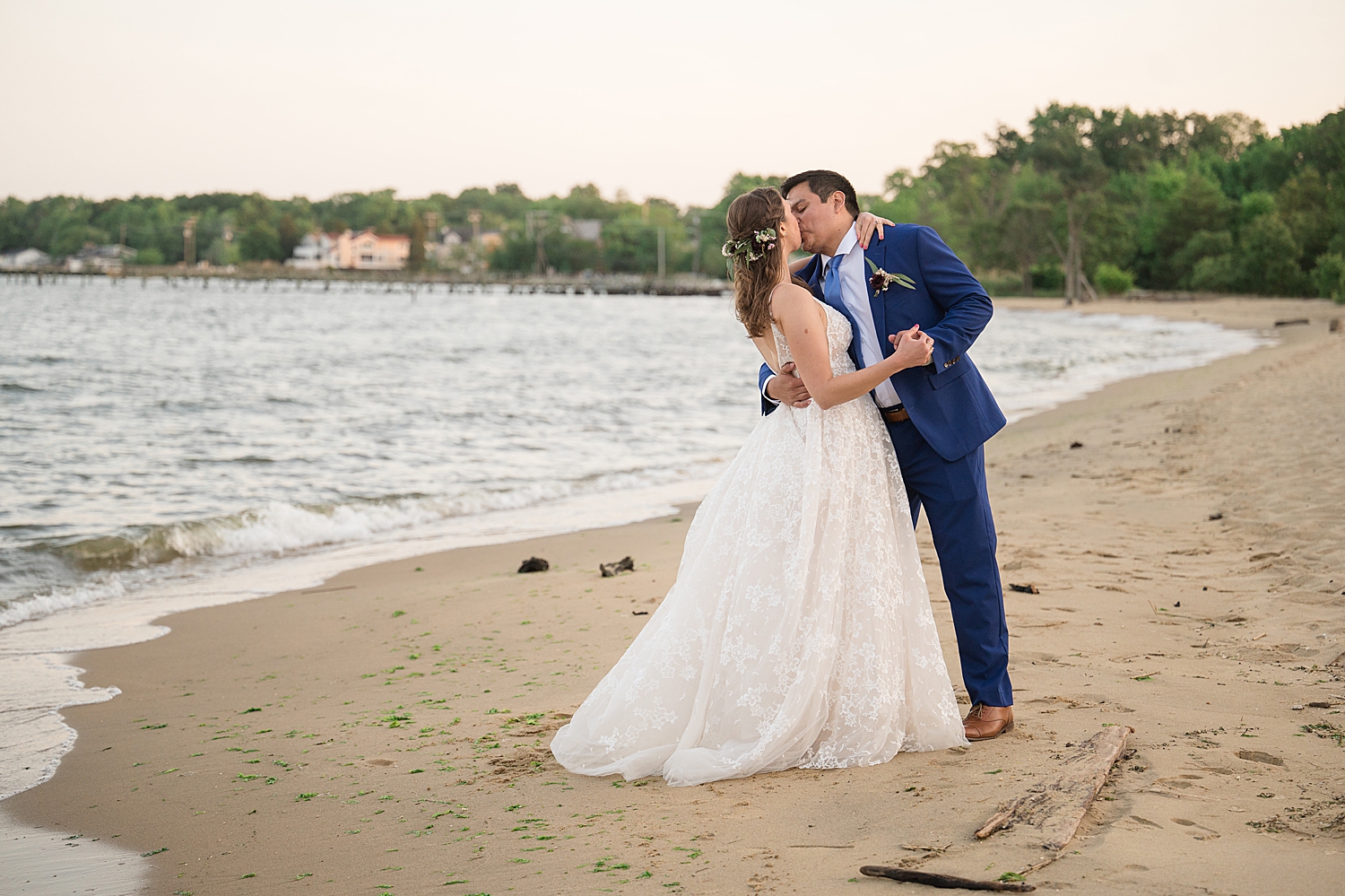 bride and groom kiss on beach