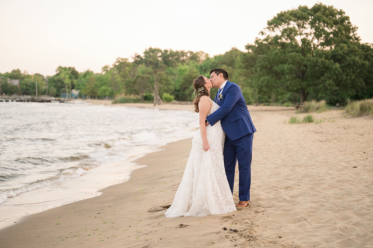 bride and groom kiss on beach