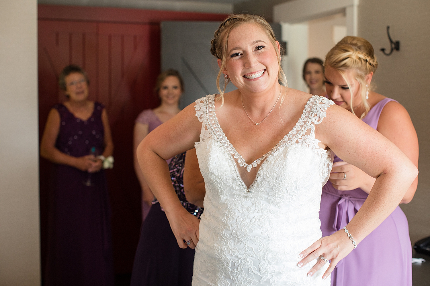 bride getting dressed, smiling at camera