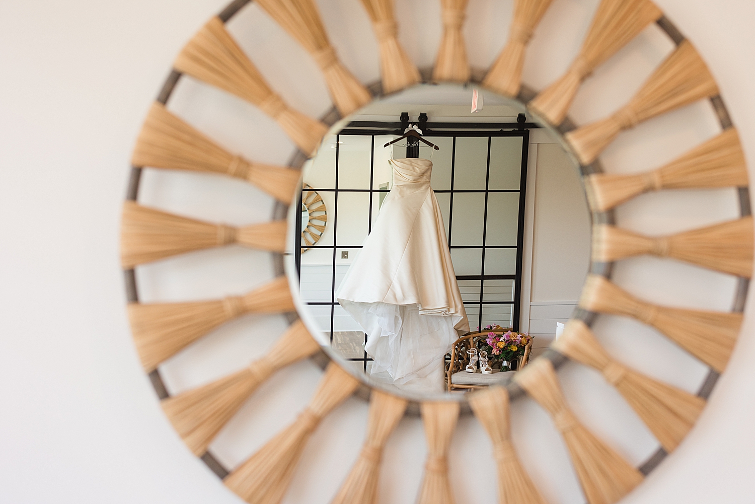 wedding dress hanging, seen in round mmirror