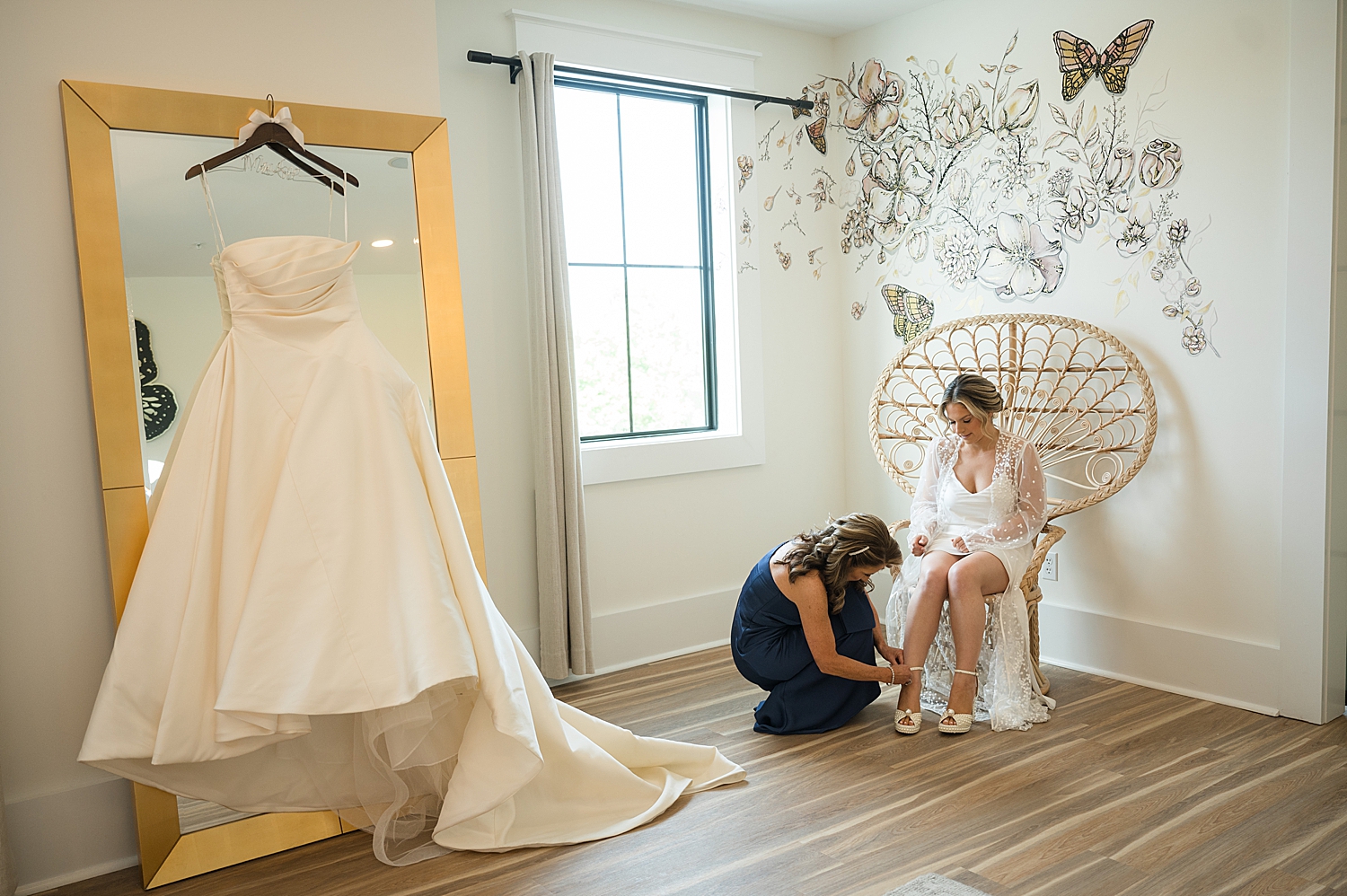 mom helping bride get into shoes