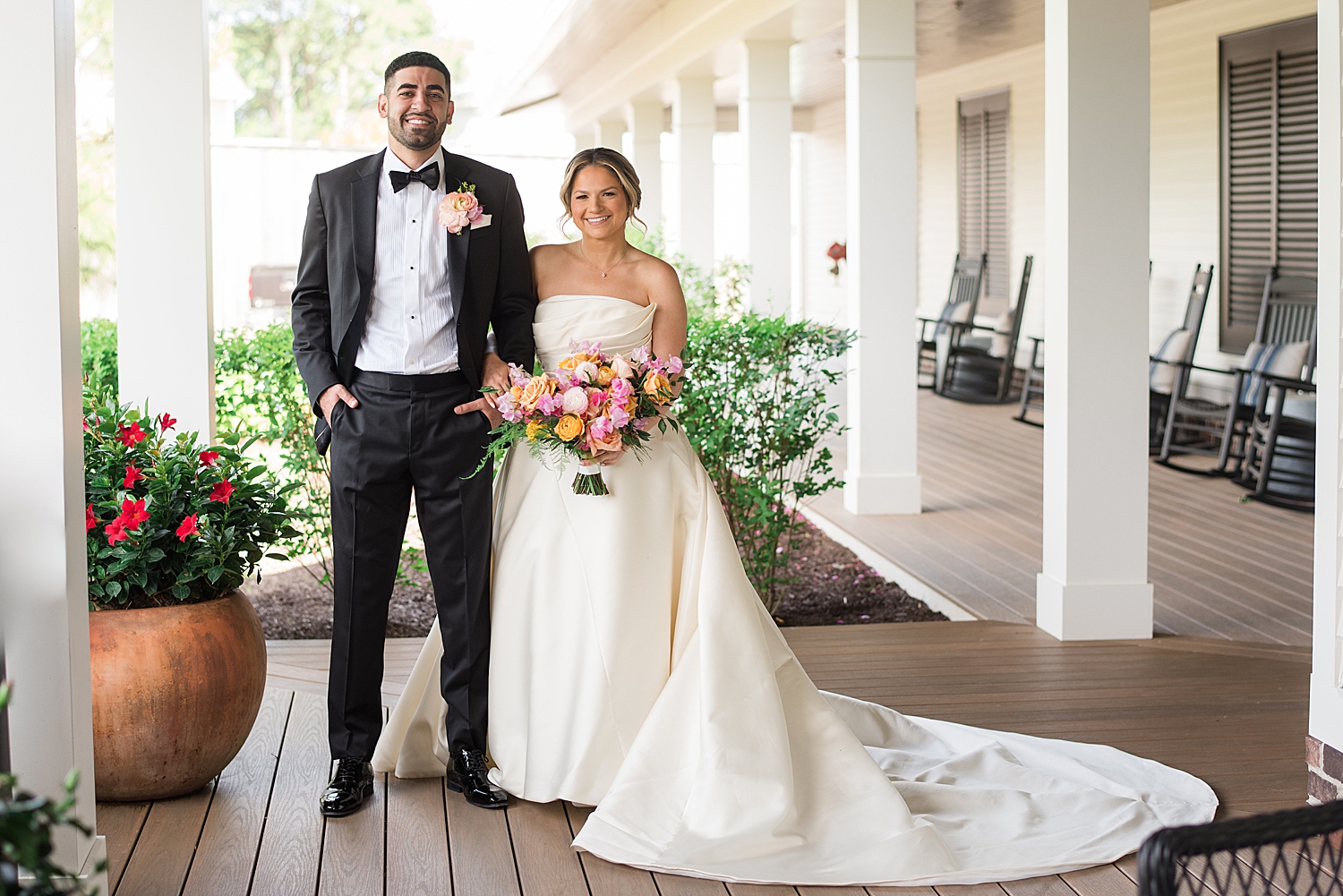 bride and groom on porch, smiling at camera