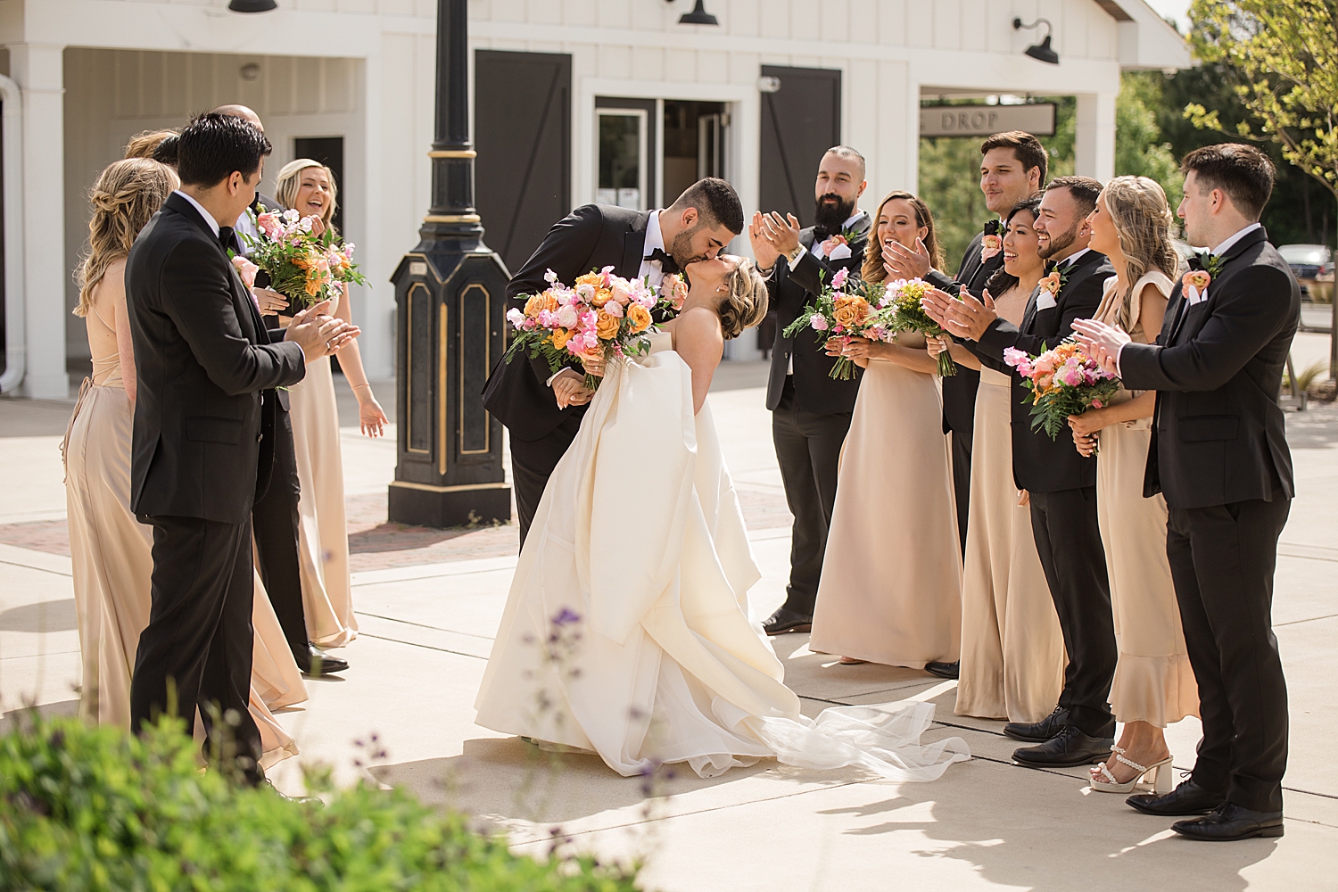 bride and groom wedding party tunnel cheer kiss