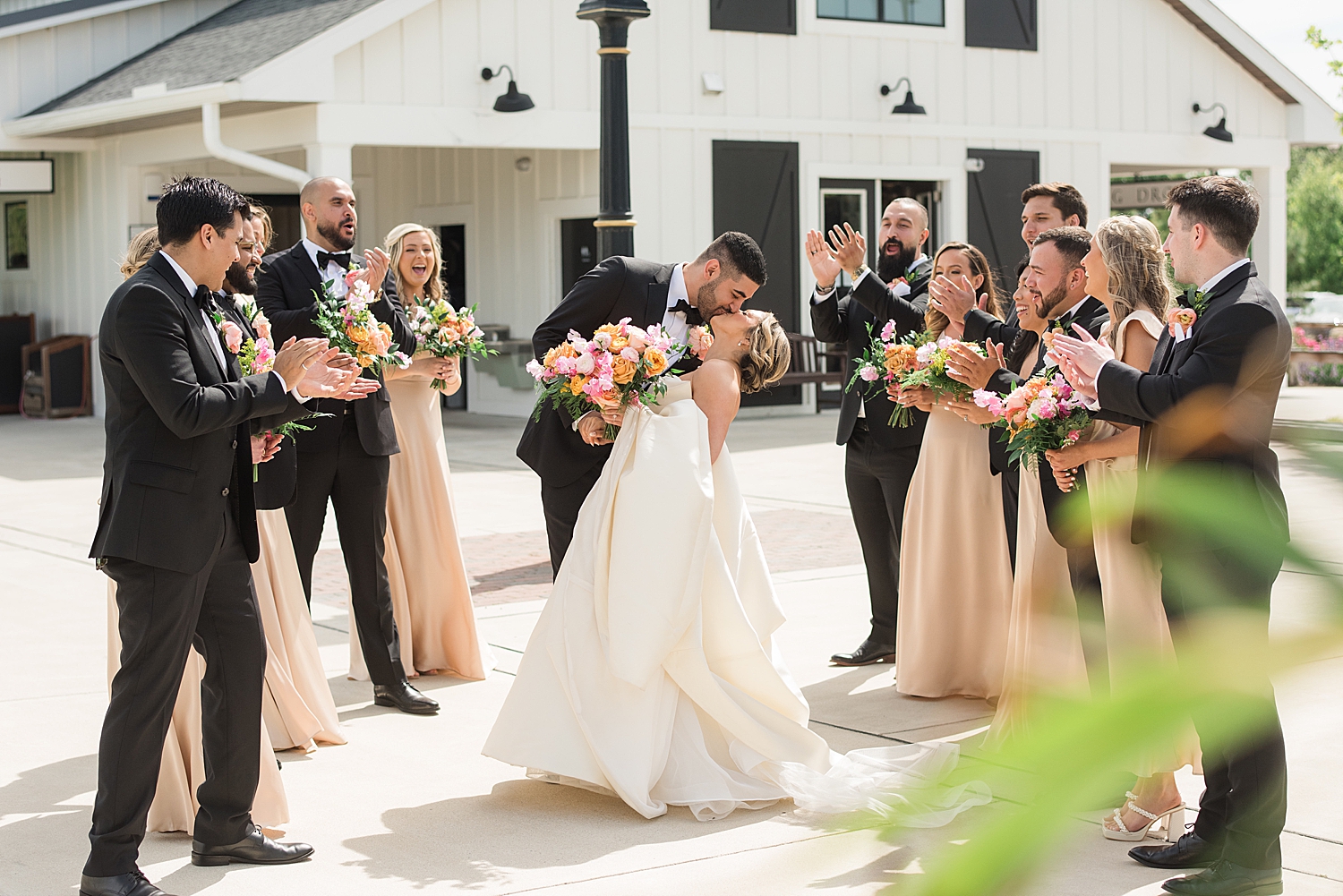 bride and groom wedding party tunnel cheer kiss