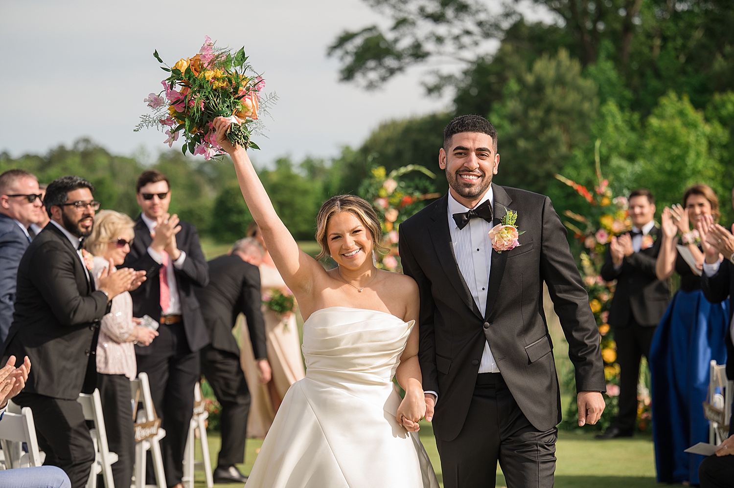 bride and groom cheer during ceremony recessional