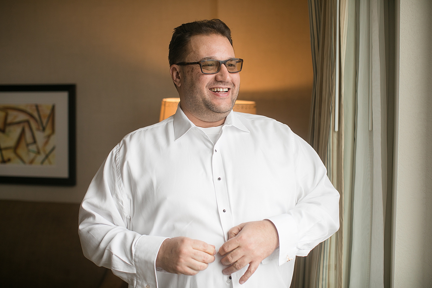 groom getting ready, buttoning shirt