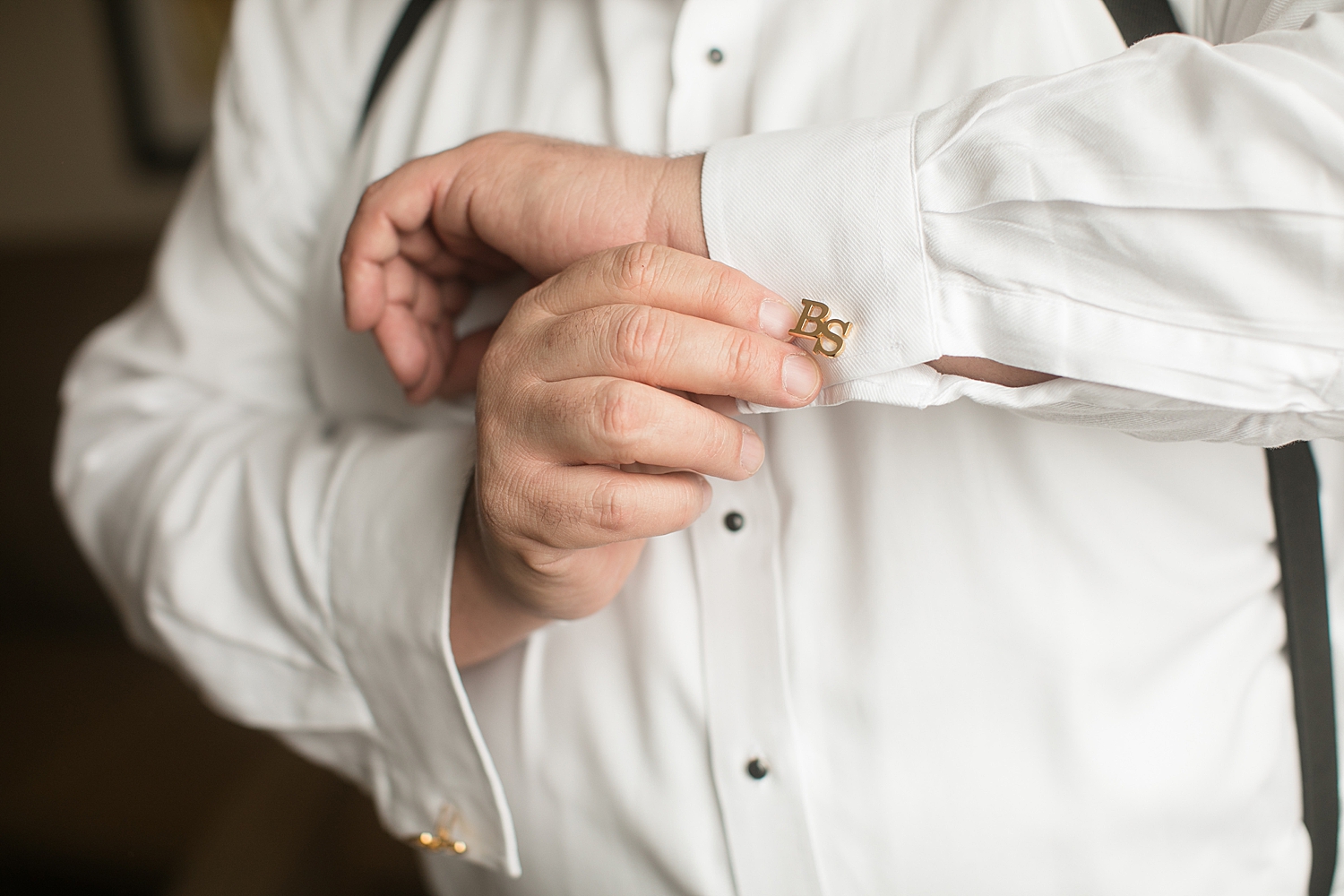 groom madjusting cufflinks