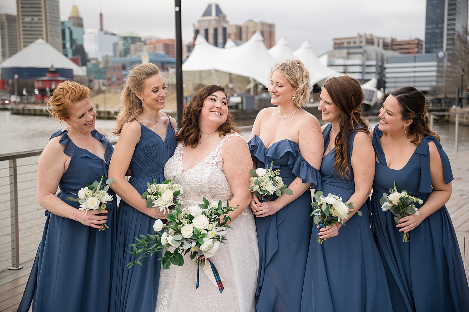 bride smiling at bridesmaids in baltimore harbor