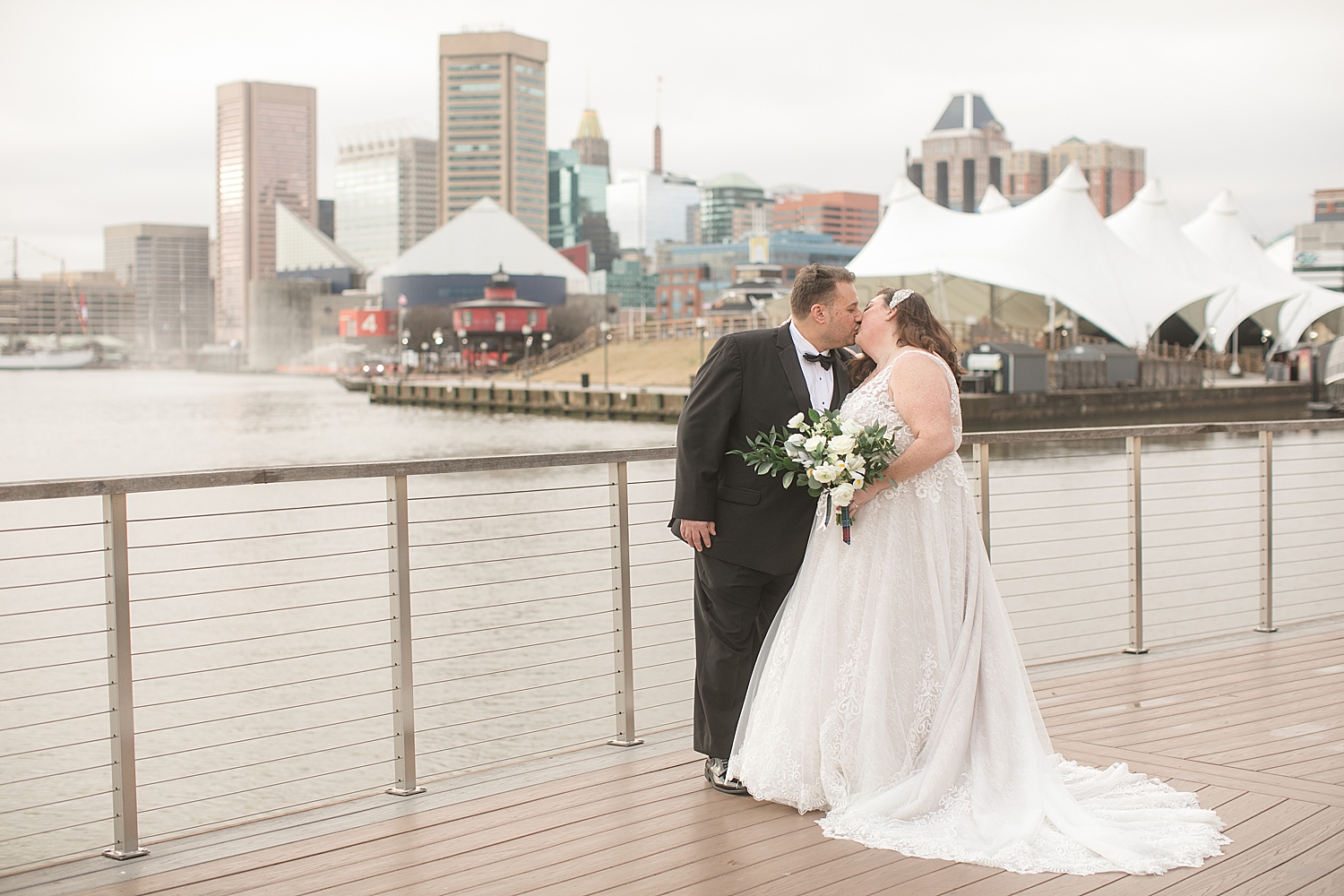 bride and groom kiss overlooking baltimore harbor