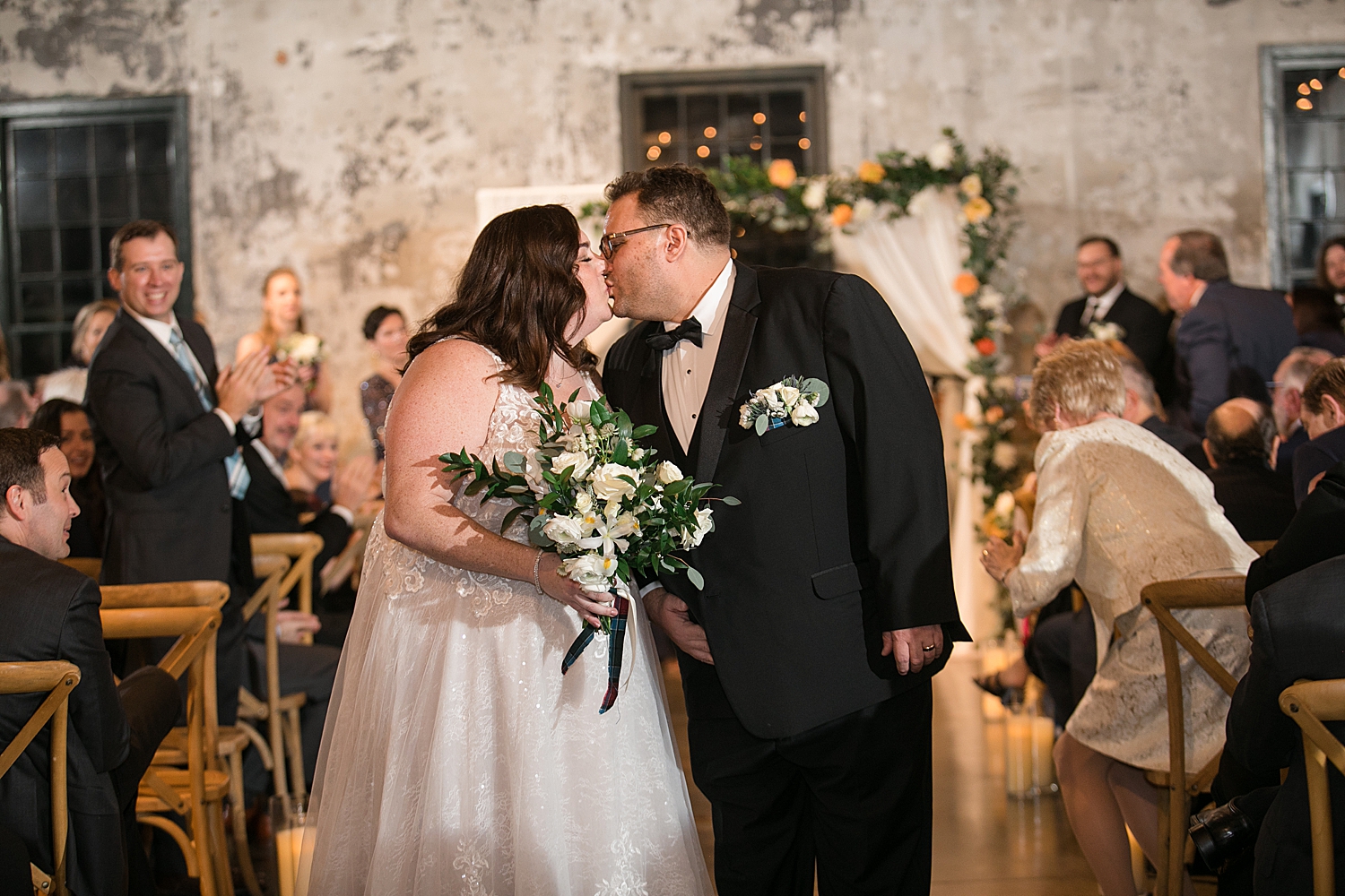 bride and groom kiss in aisle after ceremony