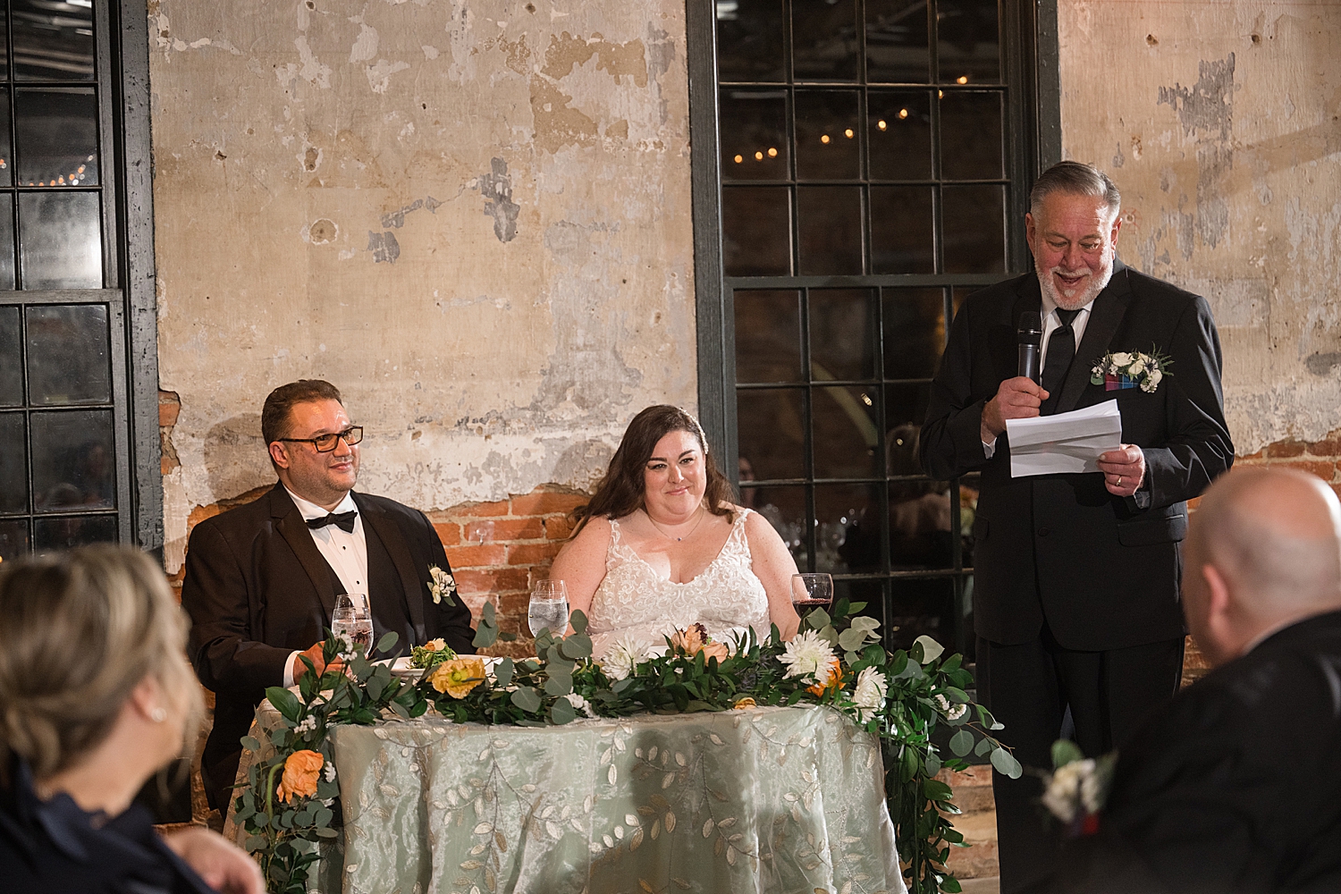 bride and groom listening and reacting to toasts