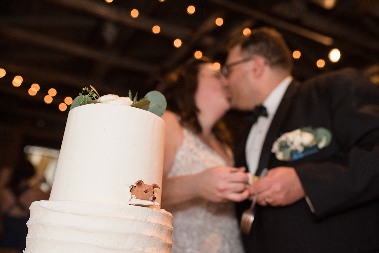 bride and groom kissing after cake cutting