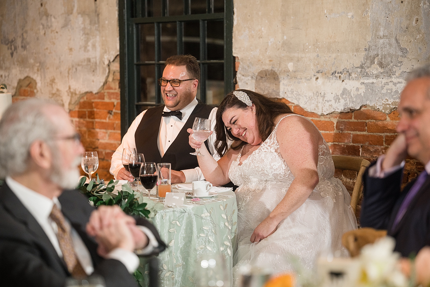 bride and groom listening and reacting to toasts