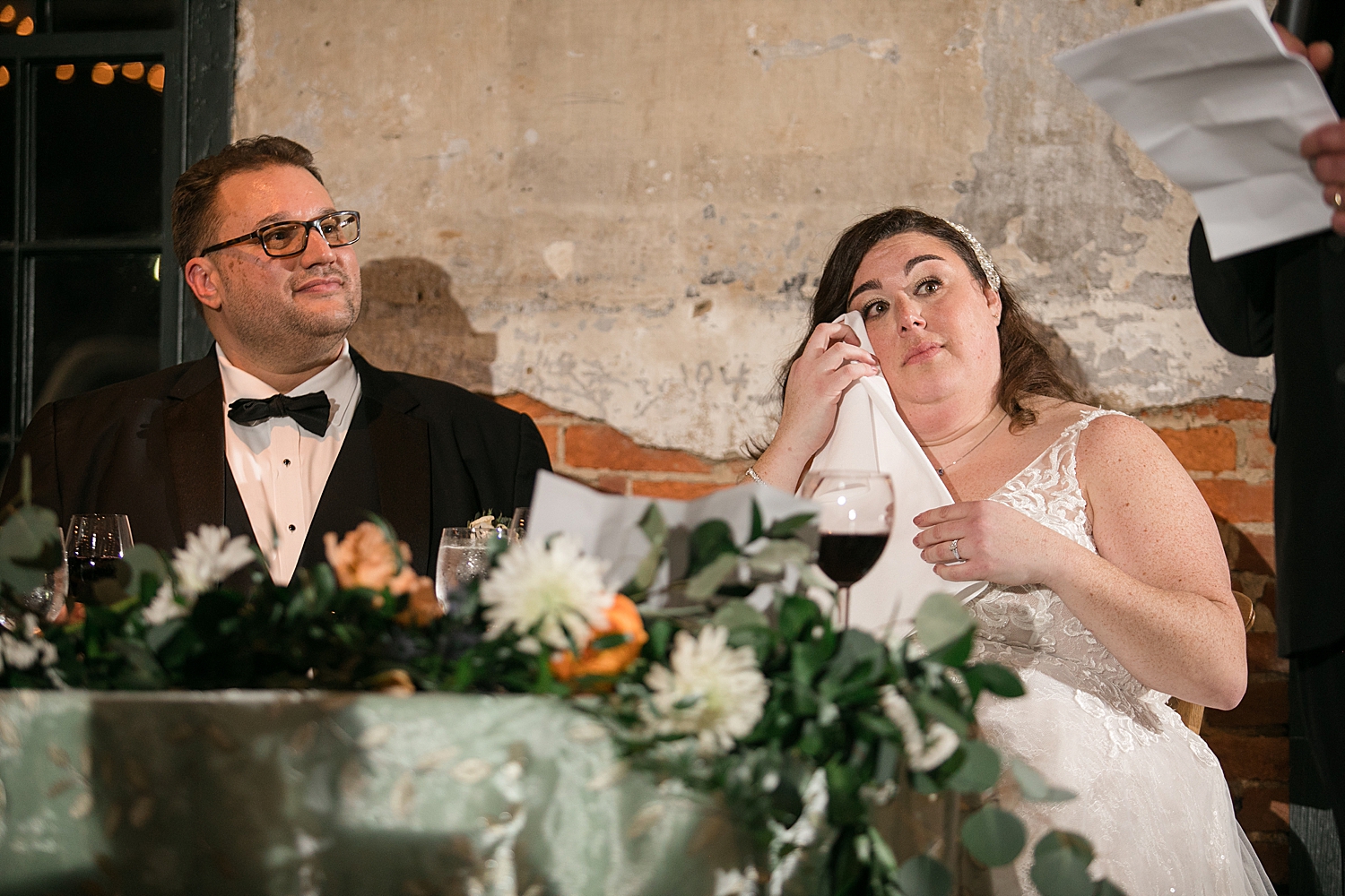 bride and groom listening and reacting to toasts