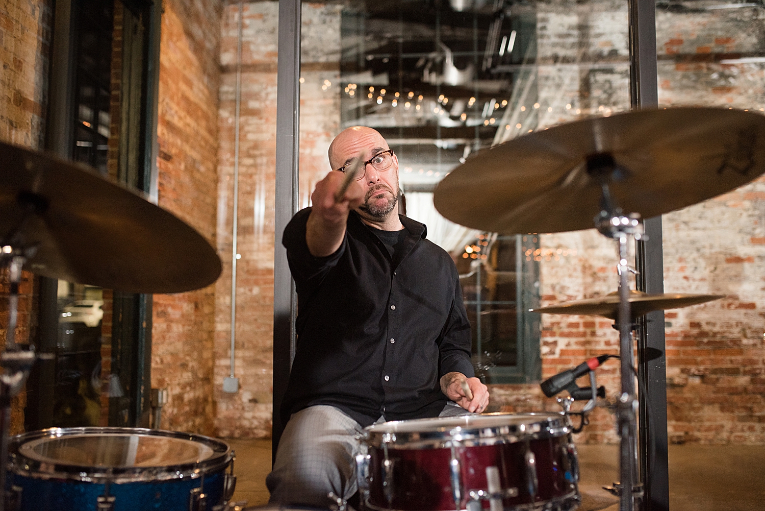 drummer pointing at camera playfully with drumstick