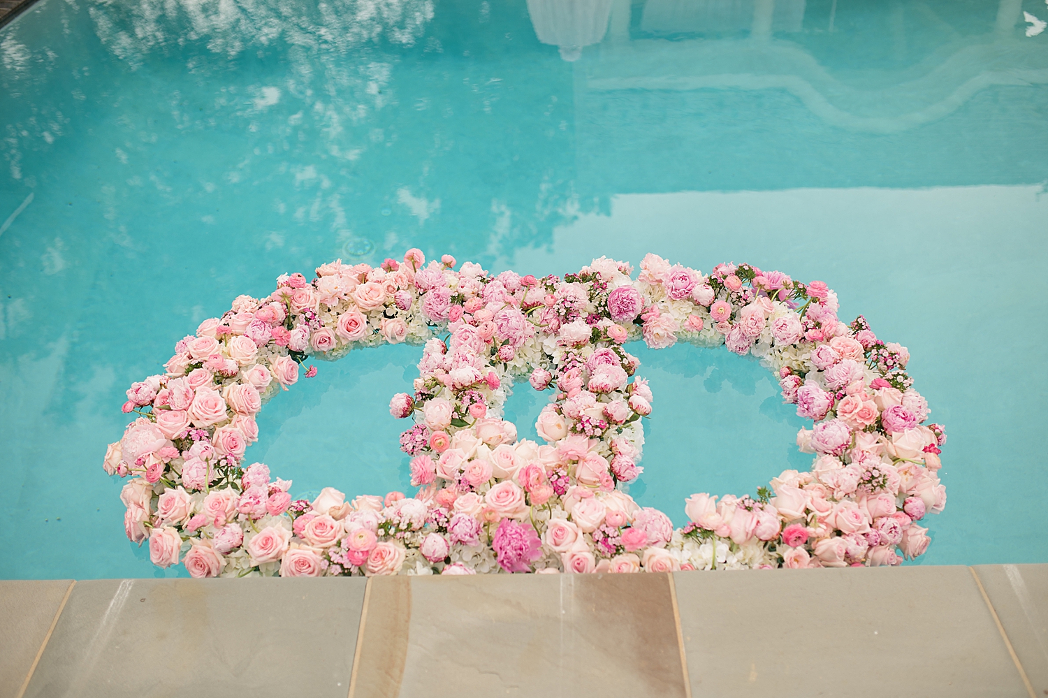 pink floral wedding bands float on pool