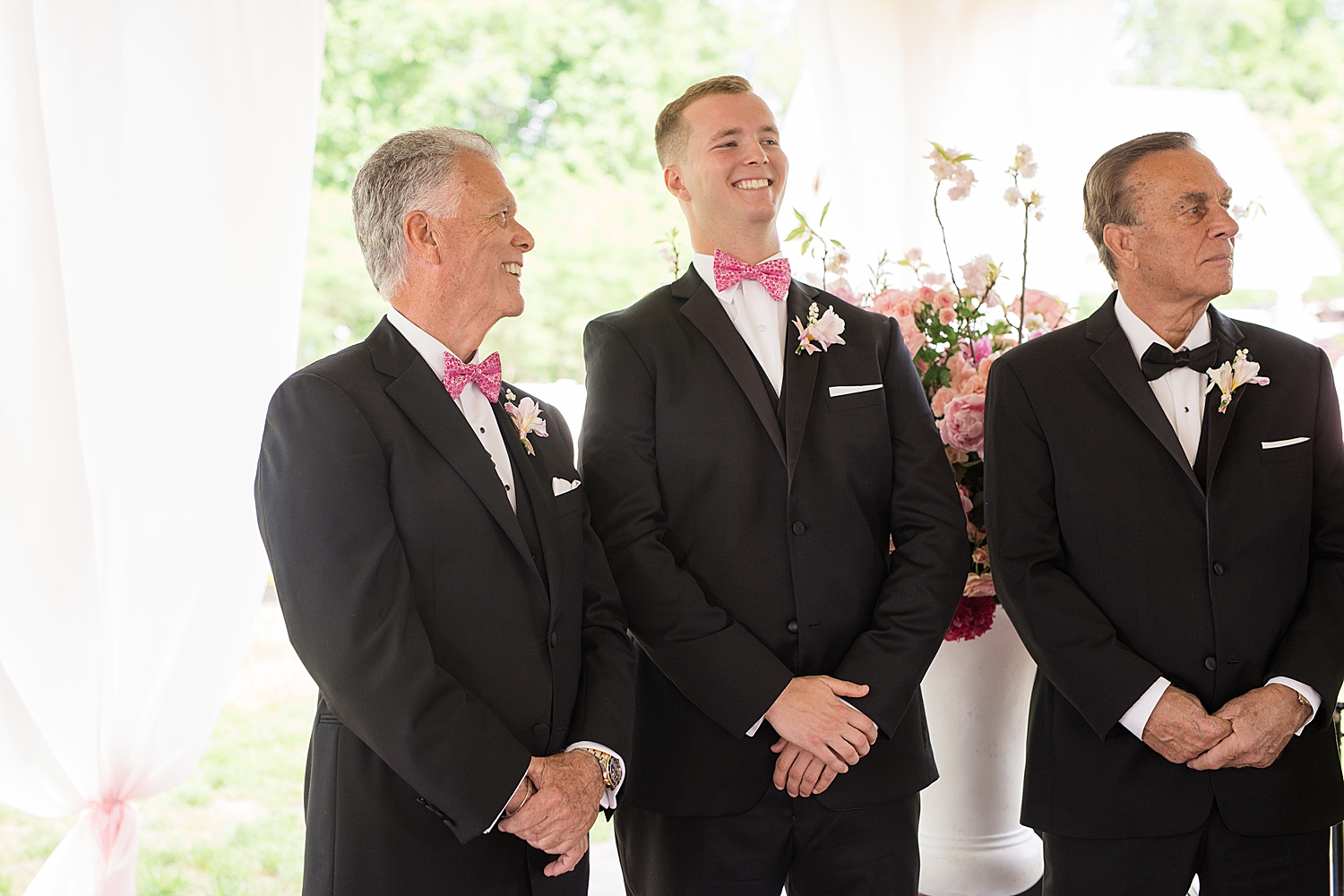 groom waits at the end of the aisle with son