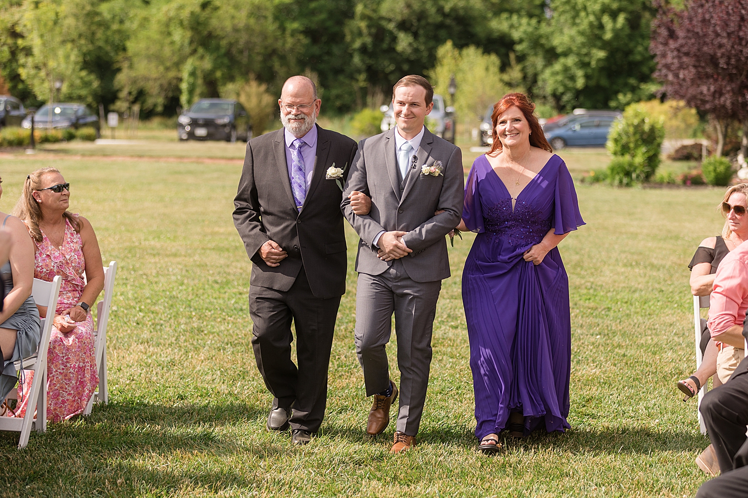 groom walking with parents down the aisle