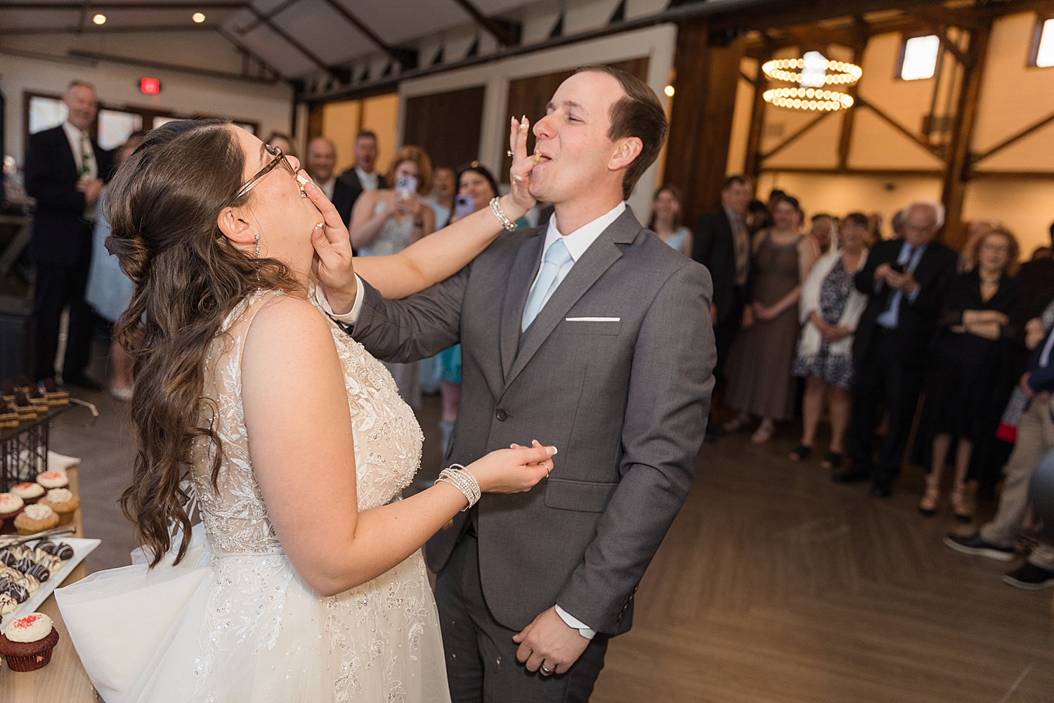 bride and groom shove cake in mouths