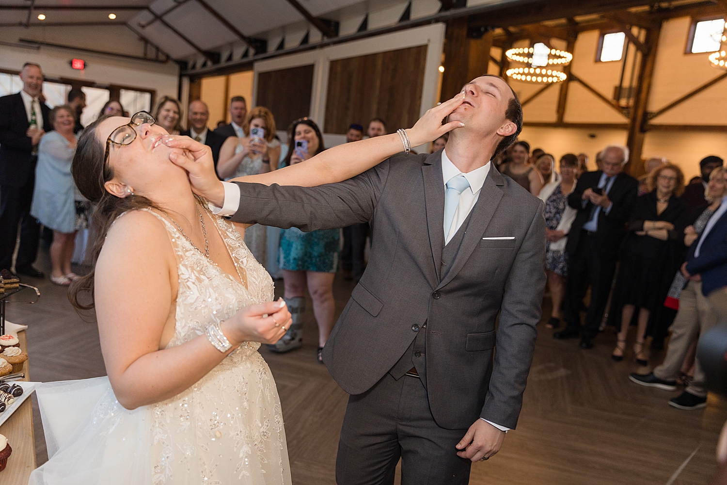 bride and groom shove cake in mouths