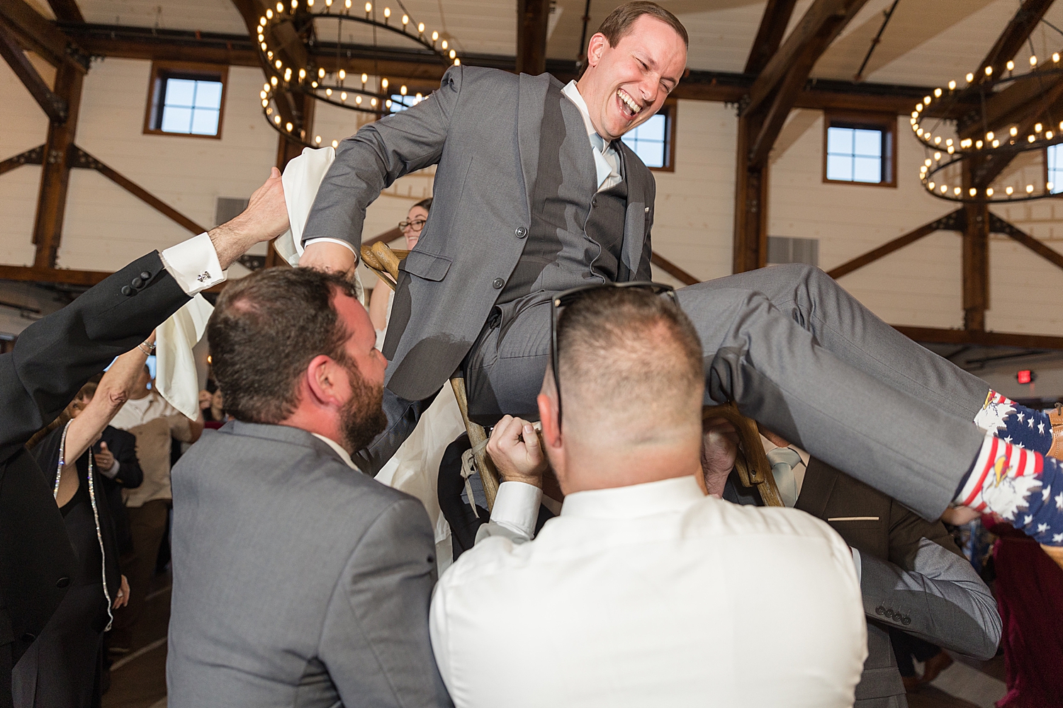 groom lifted in chair on dance floor